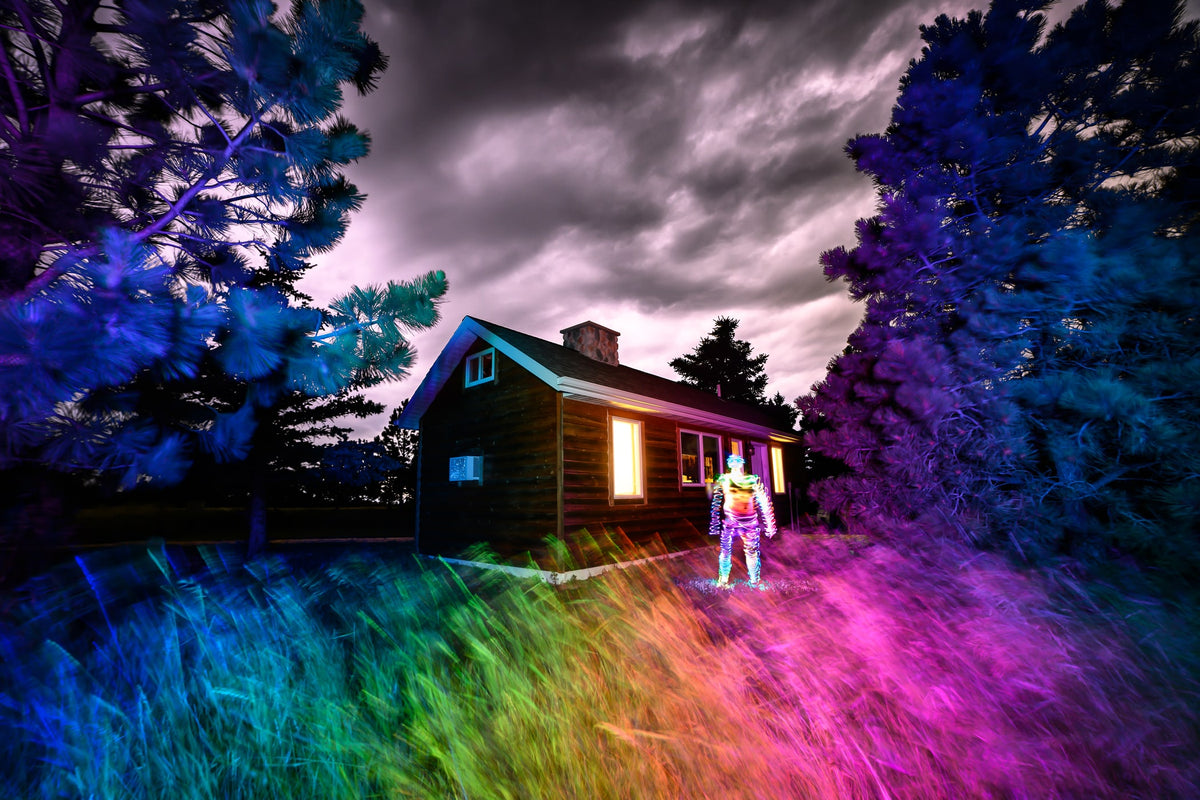 Long exposure light painting by Daniel Kessel: a cabin and field washed in rainbow color