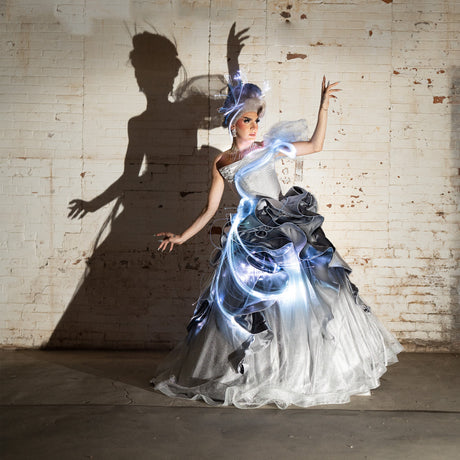 White ball gown lit with the Fiber Optic Costume Kit, fibers glowing through the ruffles. Gown by Starkers Corsetry.
