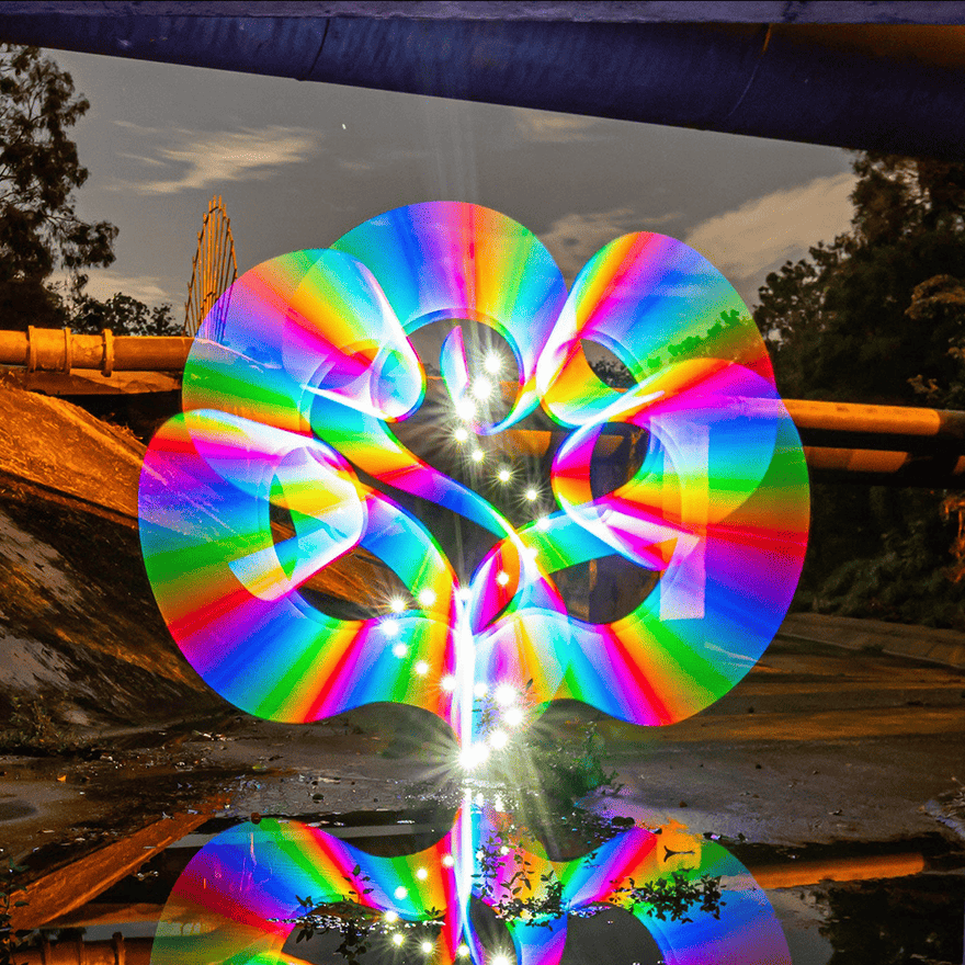 Light painting artwork of a rainbow spiral reflected in water, made with the Light Painting Tube