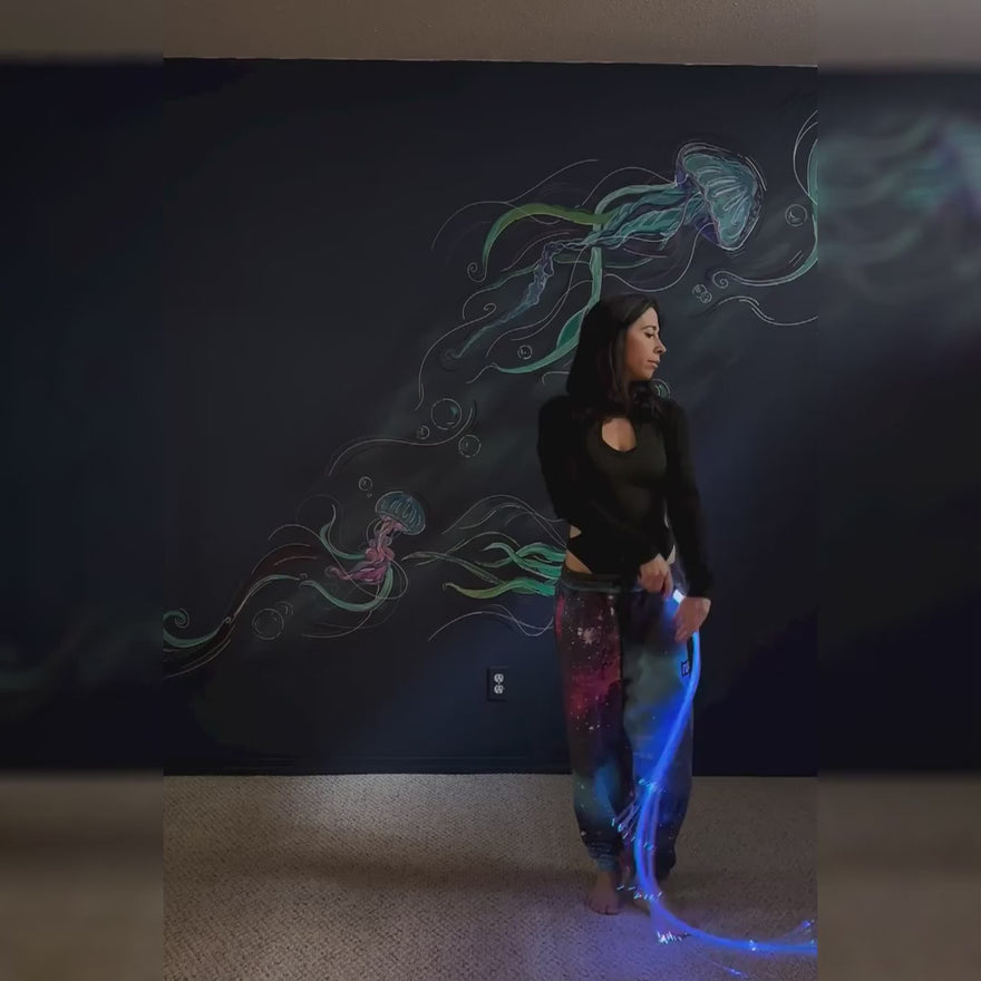 Flow artist performing with a BitWhip fiber optic whip, creating vibrant light trails