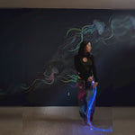 Flow artist performing with a BitWhip fiber optic whip, creating vibrant light trails