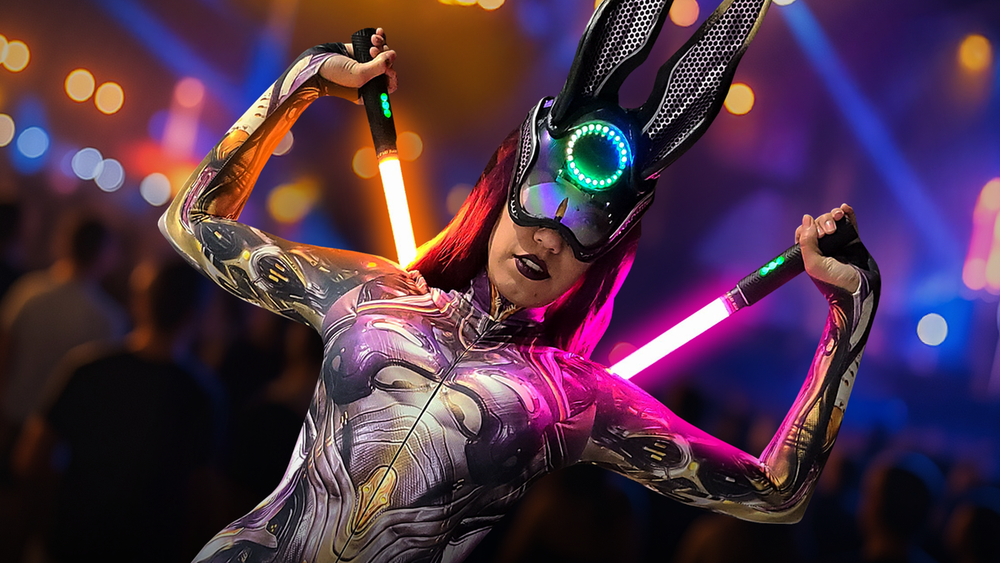 Performer creating a coordinated light show with multiple synced RGB Critter devices at a festival