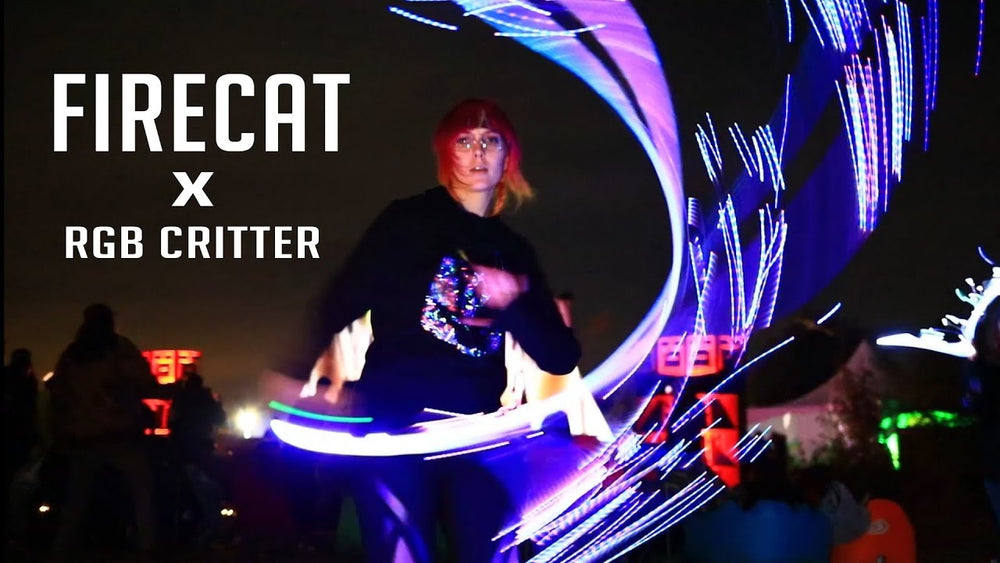 Firecat performing at night with the RGB Critter, spinning LED light trails through a festival crowd