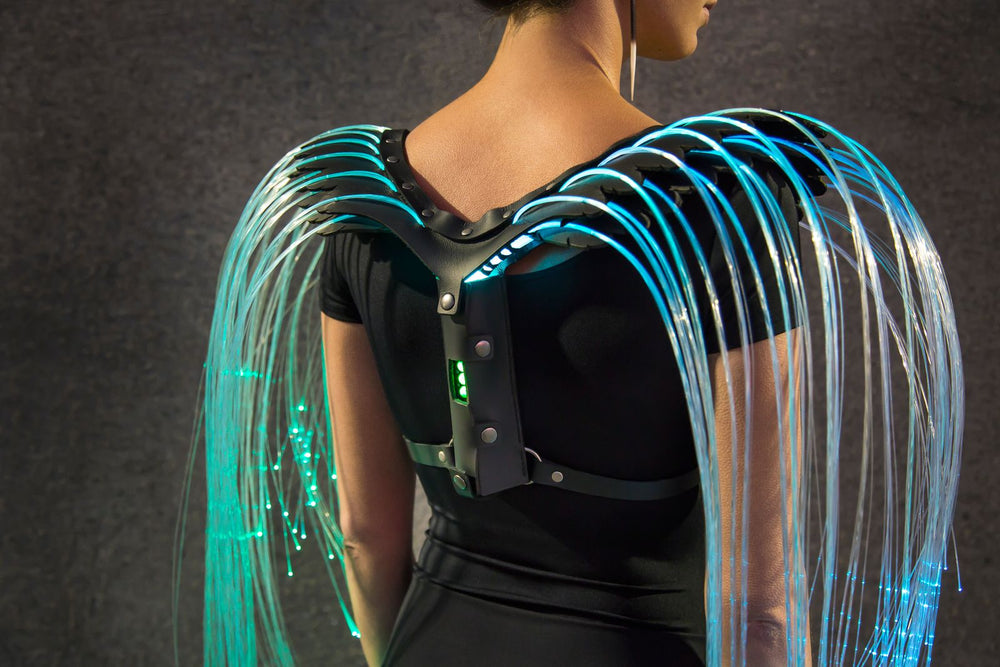 Fiber optic wings by Natalie Walsh glowing blue, the strands falling from a leather harness