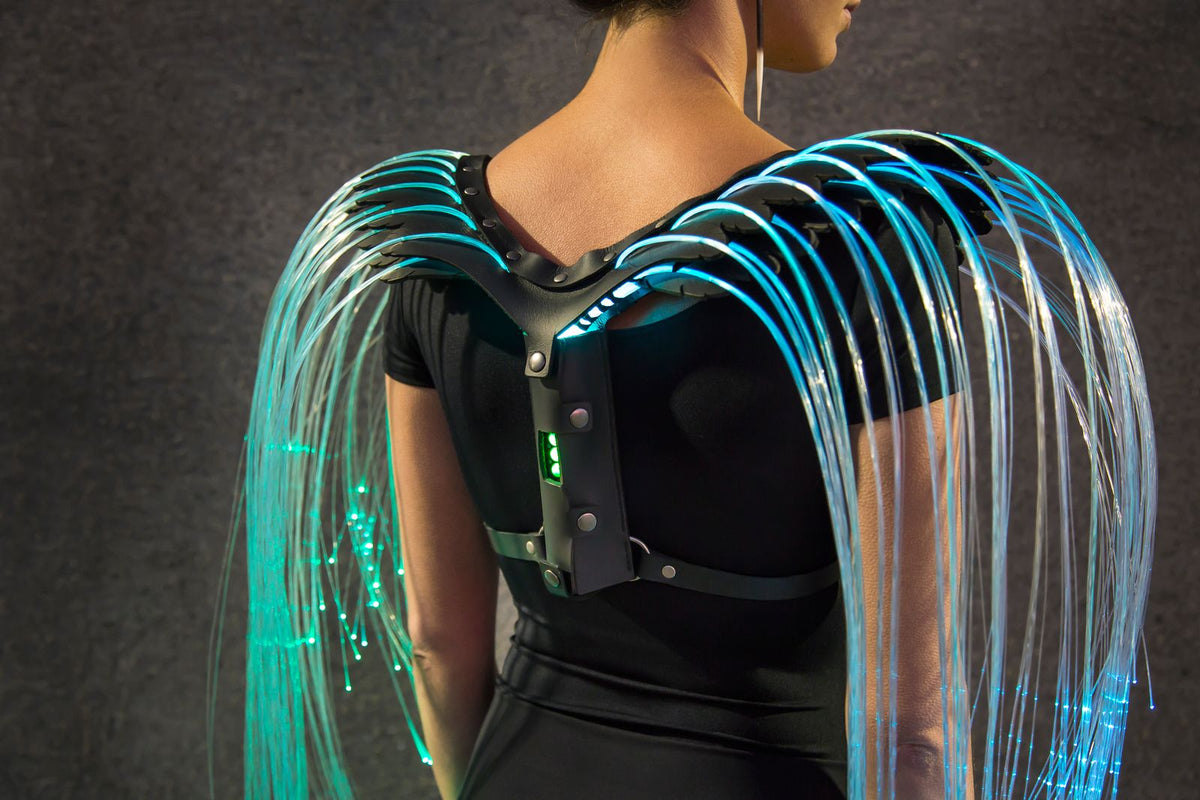 Fiber optic wings by Natalie Walsh glowing blue, the strands falling from a leather harness