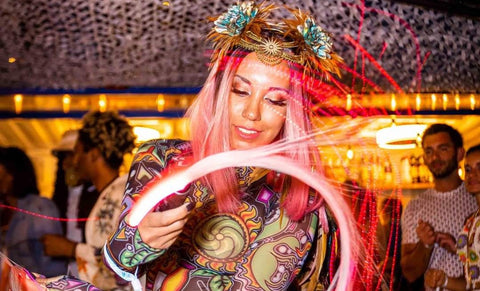 Flow artist spinning a lit fiber optic whip at a festival