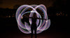 Fiber optic whip spinning glowing light trails at night