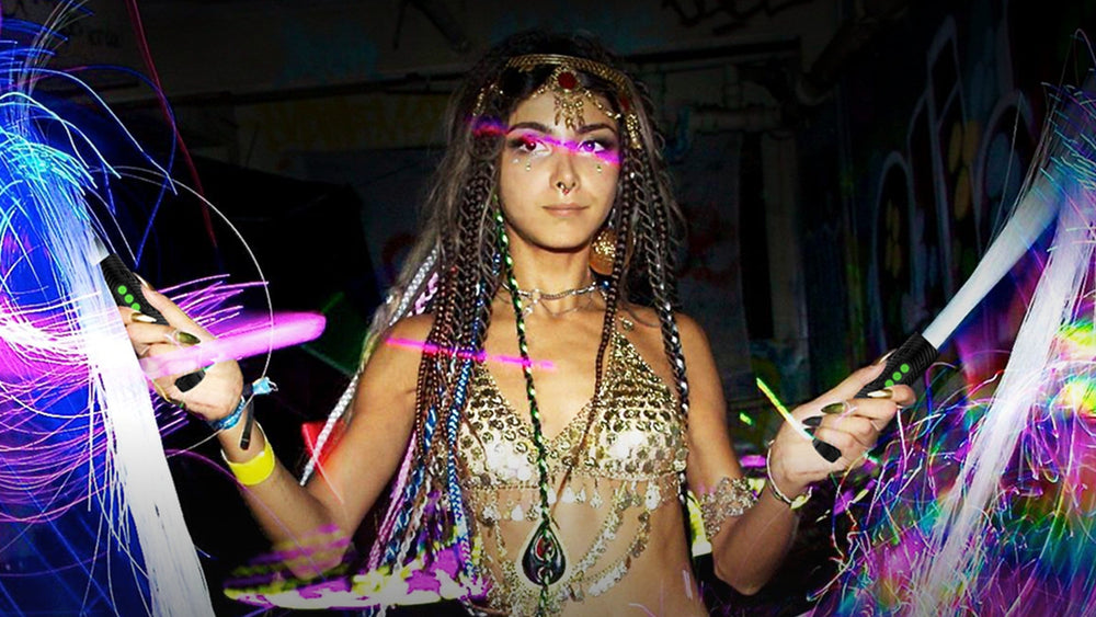 Flow artist spinning two fiber optic whips at a festival