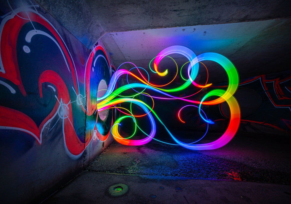 Rainbow light writing trails painted with an RGB Critter in a concrete tunnel, shot as a long exposure
