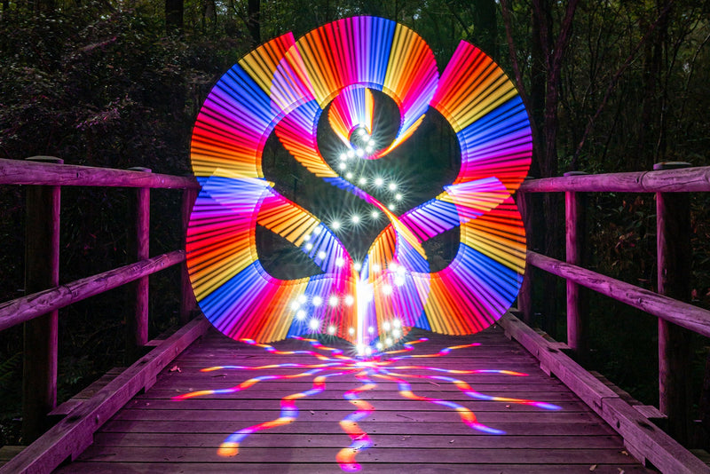 Rainbow spiral drawn with a light painting tube on a footbridge